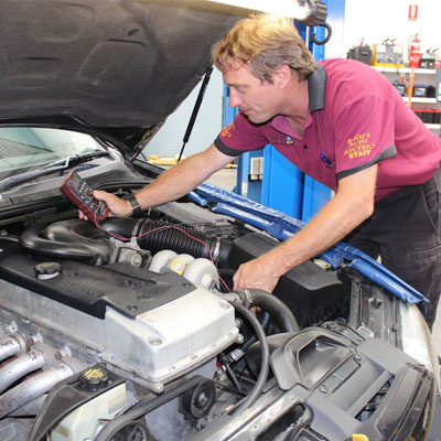 Automotive technician testing charging system for voltage irregularities
